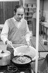 853643 Afbeelding van een gastarbeider tijdens het bereiden van een maaltijd in het gemeentelijk pension voor ...